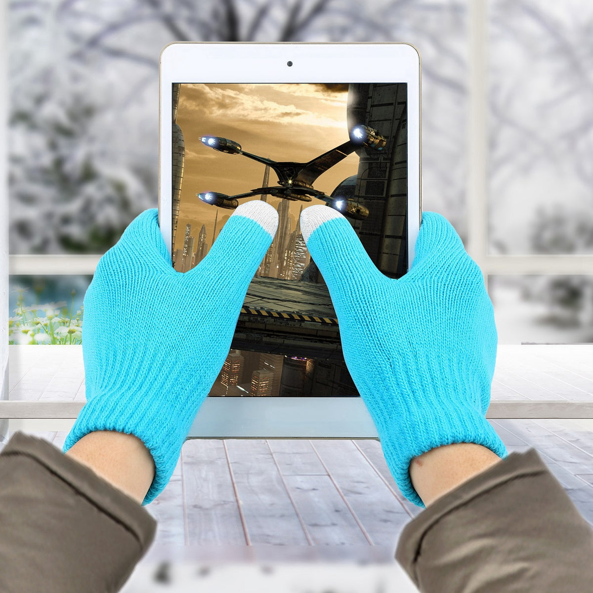 Holding a tablet while wearing the Blue touchscreen knit gloves